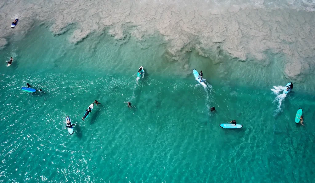 Top view of surfers surfing Selong Belanak