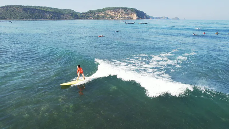 Surfista montando suaves olas de grupuk